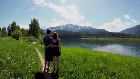 couple standing with arm around watching beautiful mountain ranges4k