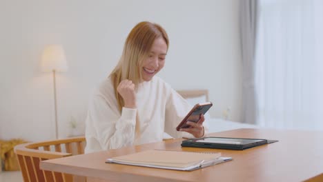 chica asiática usando teléfono inteligente jugando juegos y redes sociales o charlando con sus amigas.