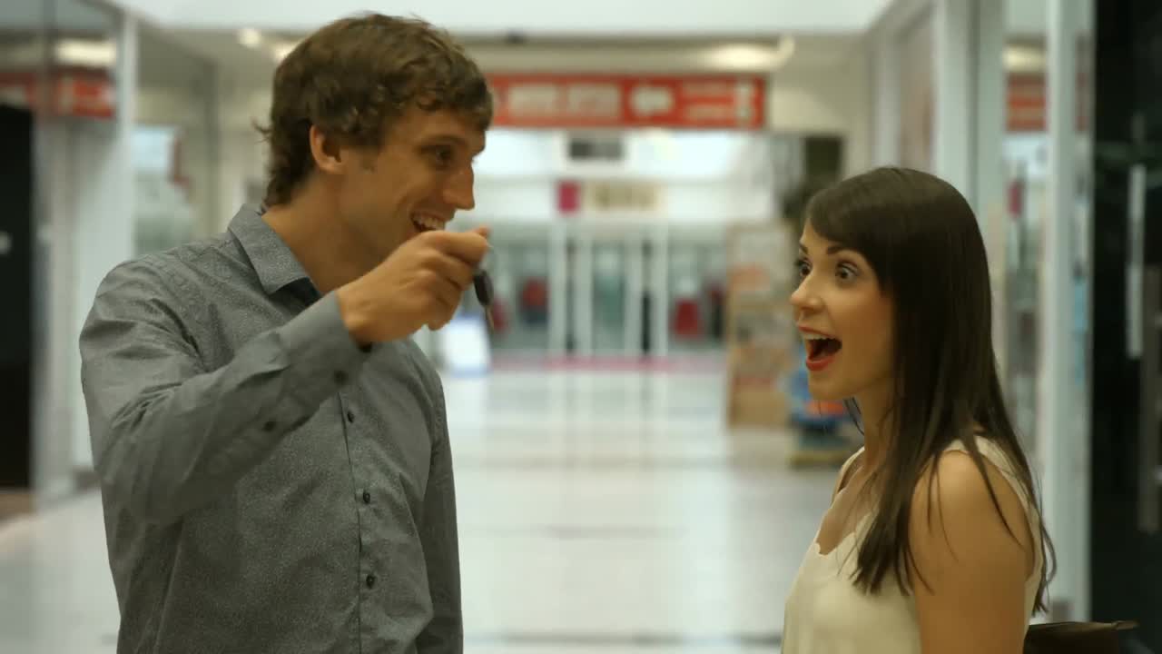 pareja sonriente discutiendo en el centro comercial