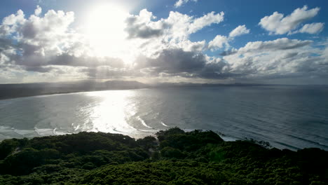 scenic aerial view of byron bay's coastline with lush greenery and sunlit ocean waves