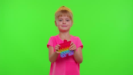 Child-girl-playing-squishy-silicone-bubbles-sensory-toy-simple-dimple-pop-it-game,-green-chroma-key