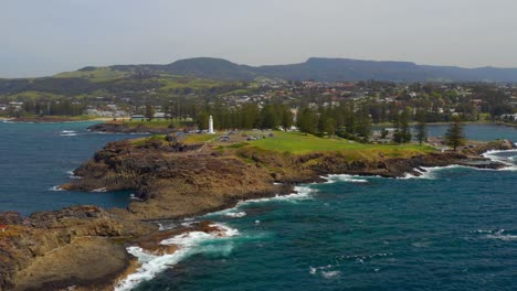 faro de kiama en el punto del agujero de soplado con olas rompiendo en la costa rocosa