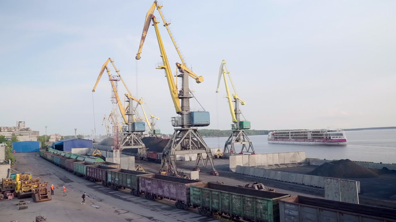 Port Cranes Loading Freight Trains Dock, Yellow Gantry Cranes Lift Bulk Cargo From Railcars At Waterfront. Creative