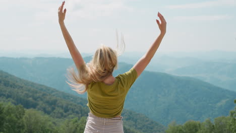 dama juega con el cabello suelto disfrutando de la alegría con la vista de las tierras altas