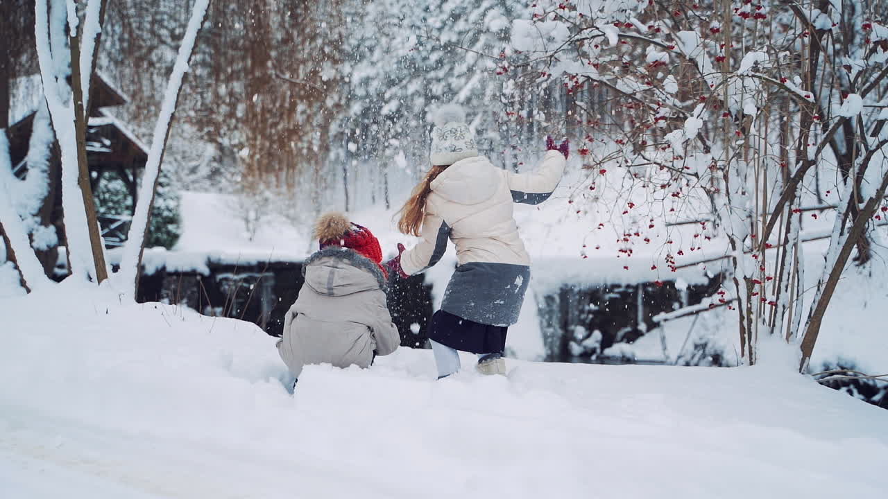 Children play outdoors in snow. Outdoor fun for family Christmas vacation.
