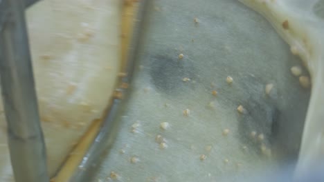 close-up view inside a mixing vat as almonds are being added to a batch of turkish delight