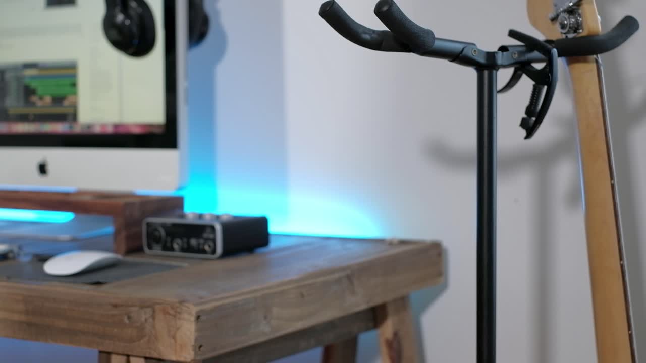 un disparo medio de un hombre tocando solos de guitarra, acordes y ritmo con el bajo en un estudio centrándose en las manos