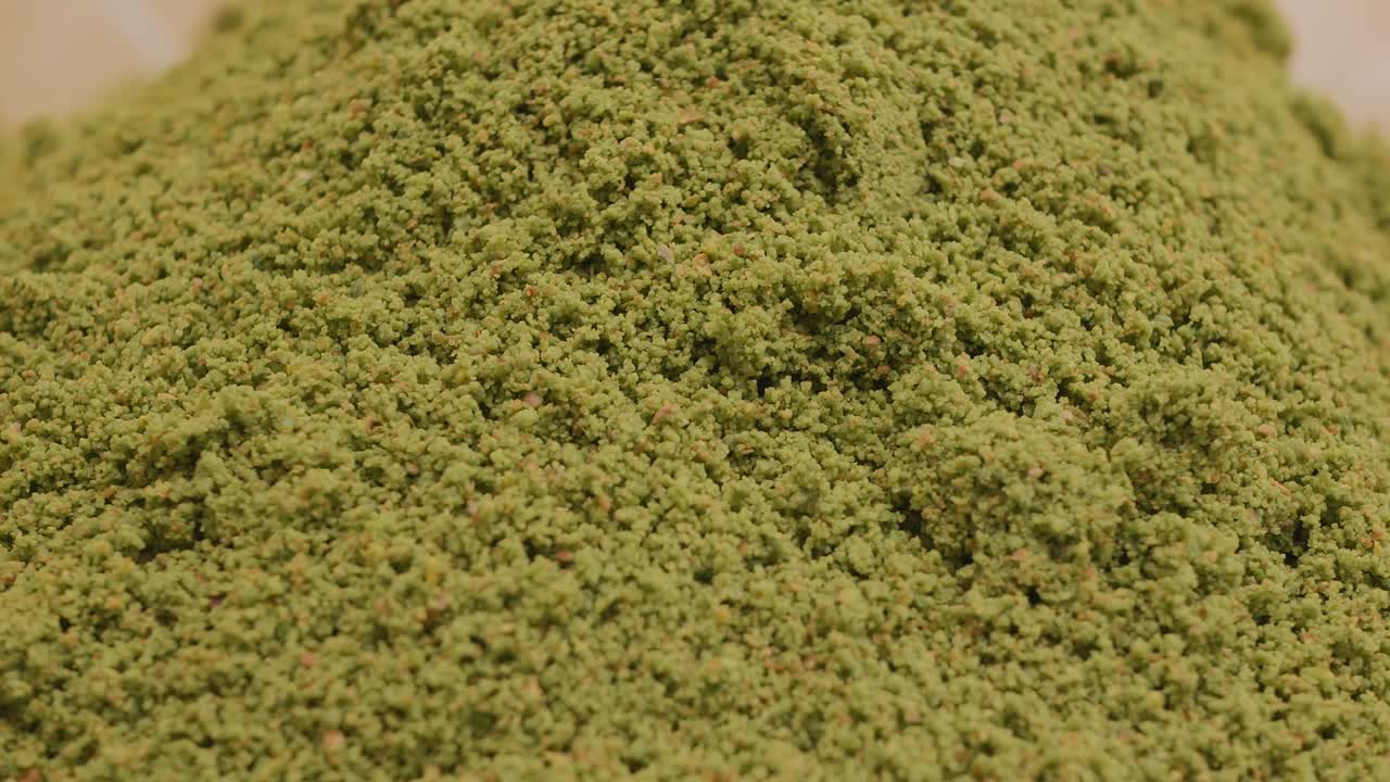 개진 피스타치오 한 어리가 밀에서 어집니다. 페이스트리 셰프는 터키 바클라바를 만들기 위해 스쿠프로 녹색 피스타치우 그라을 가져갑니다.