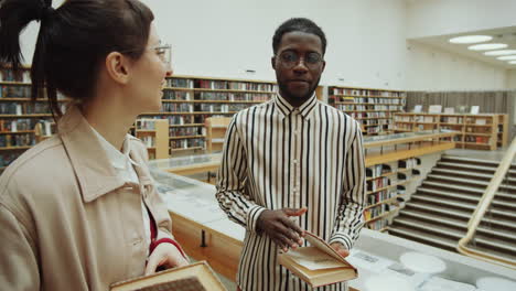 diverse friends discussing books in library