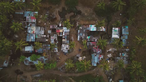 Vista-Aérea-Hacia-Abajo-De-Unas-Casitas-Pobres-Rodeadas-De-Basura-En-Medio-De-La-Jungla-En-El-País-Tropical-De-Indonesia