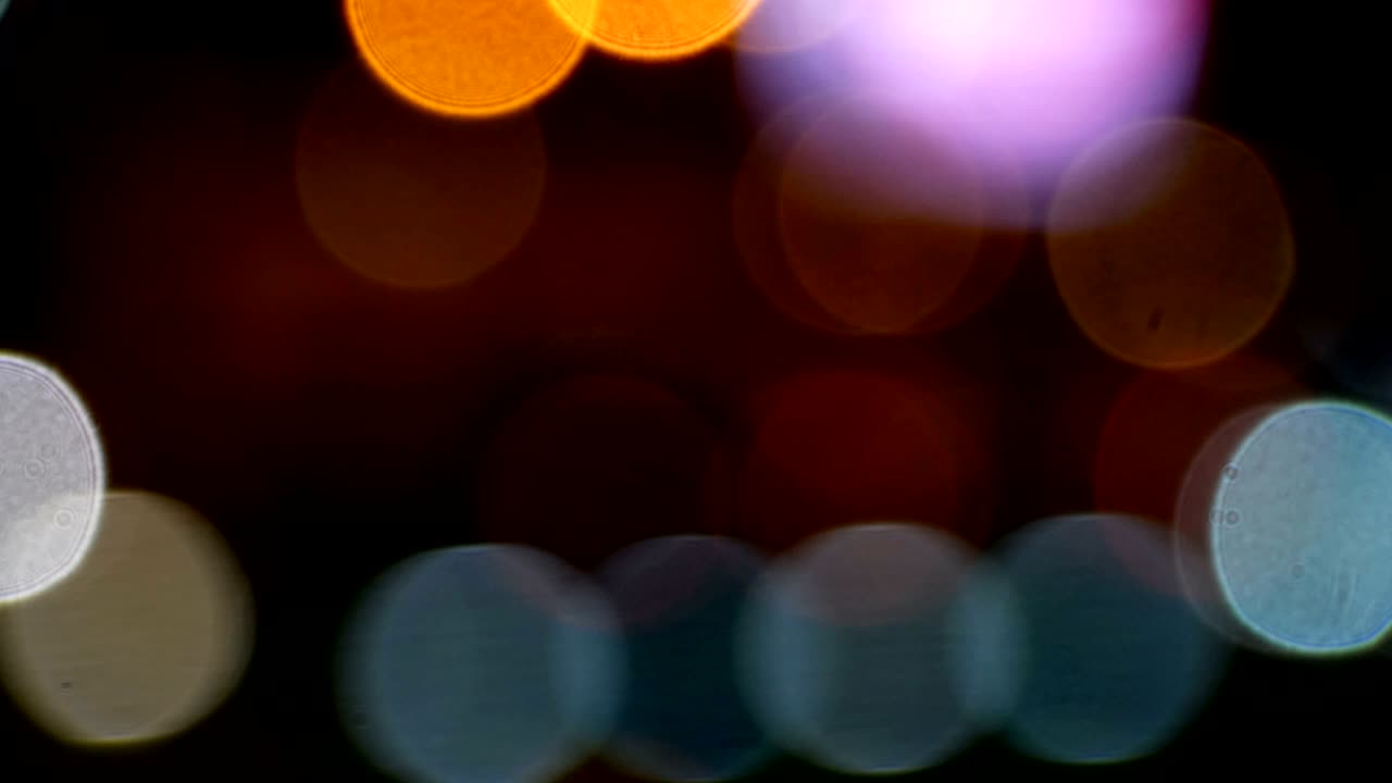 4k. borrón abstracto de bokeh brillante de coche en las luces de la calle. brillo abstracto desfocado fondo de luz de colores