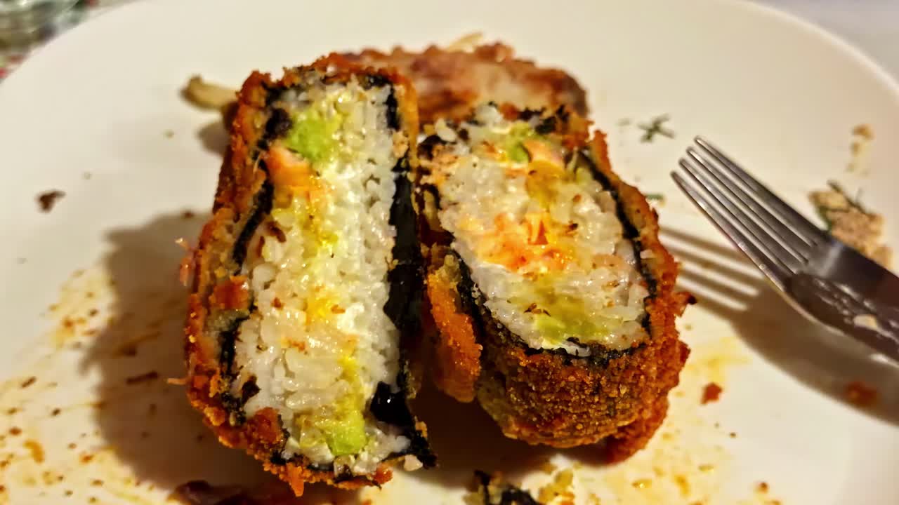 Polpette fritte di riso per sushi in tempura su un piatto, che mostrano una panatura croccante e un colore dorato
