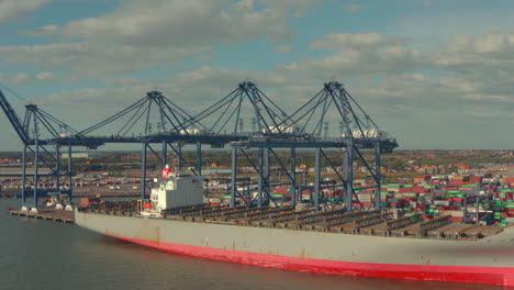 circling drone shot of rusted old container ship docked at port