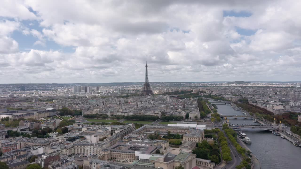 A breathtaking aerial drone shot flying towards the Eiffel Tower rising above Paris with the Seine River winding through the city’s historic skyline
