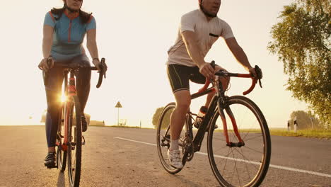 a man and a woman ride sports bikes on the highway at sunset in gear and protective helmets in slow motion 120 fps.