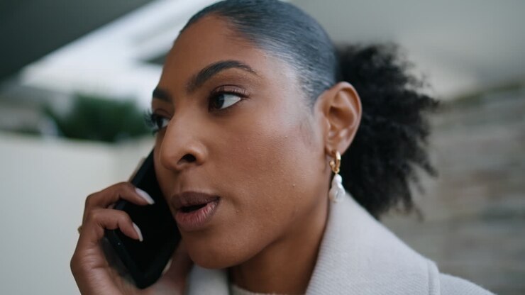 Closeup african american talking phone on street. Serious businesswoman calling