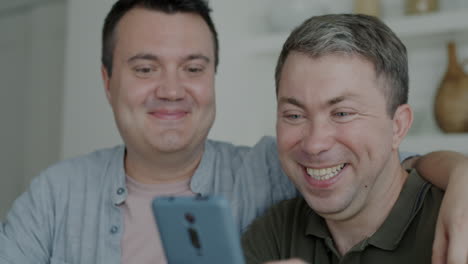 two men watching a video on their phone