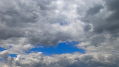 multiple clouds accumulate in the atmosphere. low angle view on the grey cloudscape gathering in the sky. timelapse.
