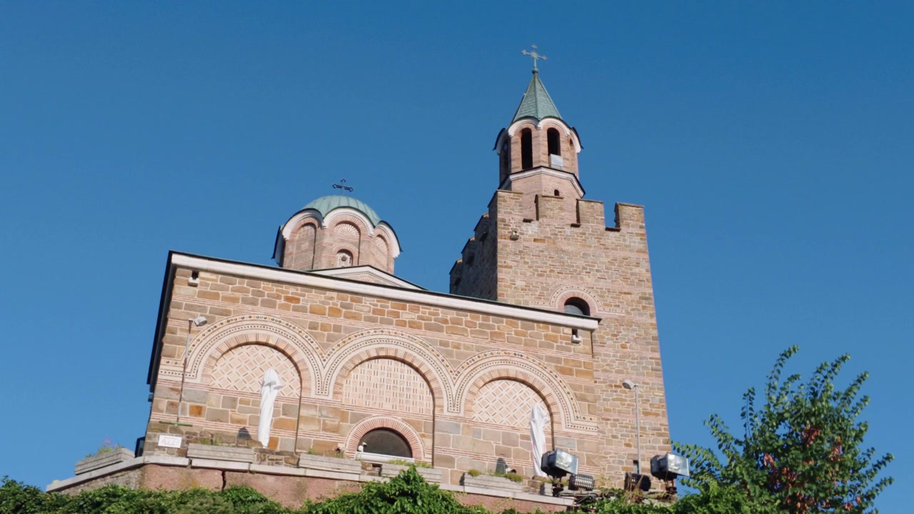 Edificio storico di una chiesa a Veliko Tarnovo, Bulgaria, visto contro un cielo estivo limpido e blu, che mostra l'architettura religiosa tradizionale europea.