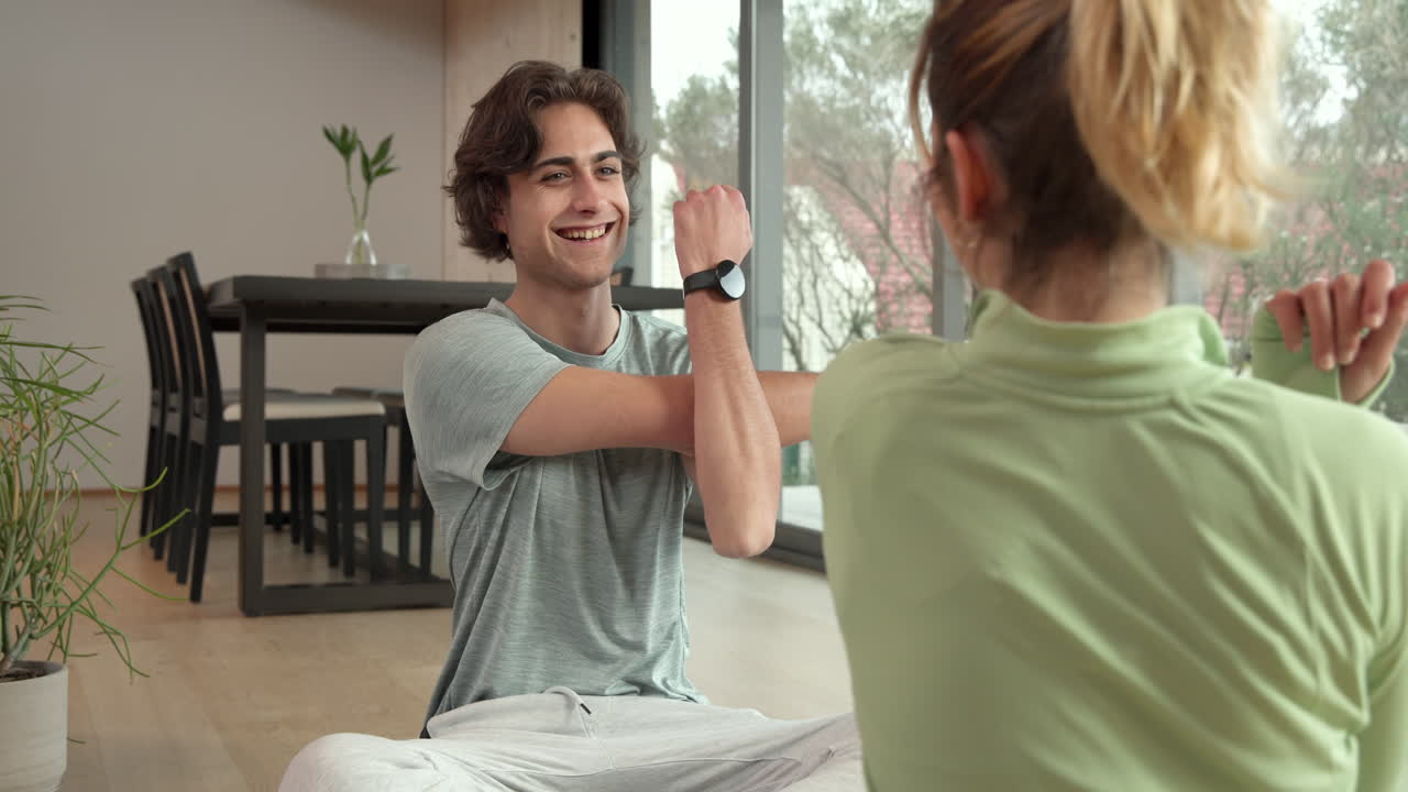 Stretching together, couple doing morning workout at home, focusing on flexibility