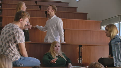 el grupo de estudiantes felices y alegres sentados en una sala de conferencias antes de la lección