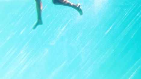 Sexy-blonde-in-blue-bikini-jumping-into-the-swimming-pool