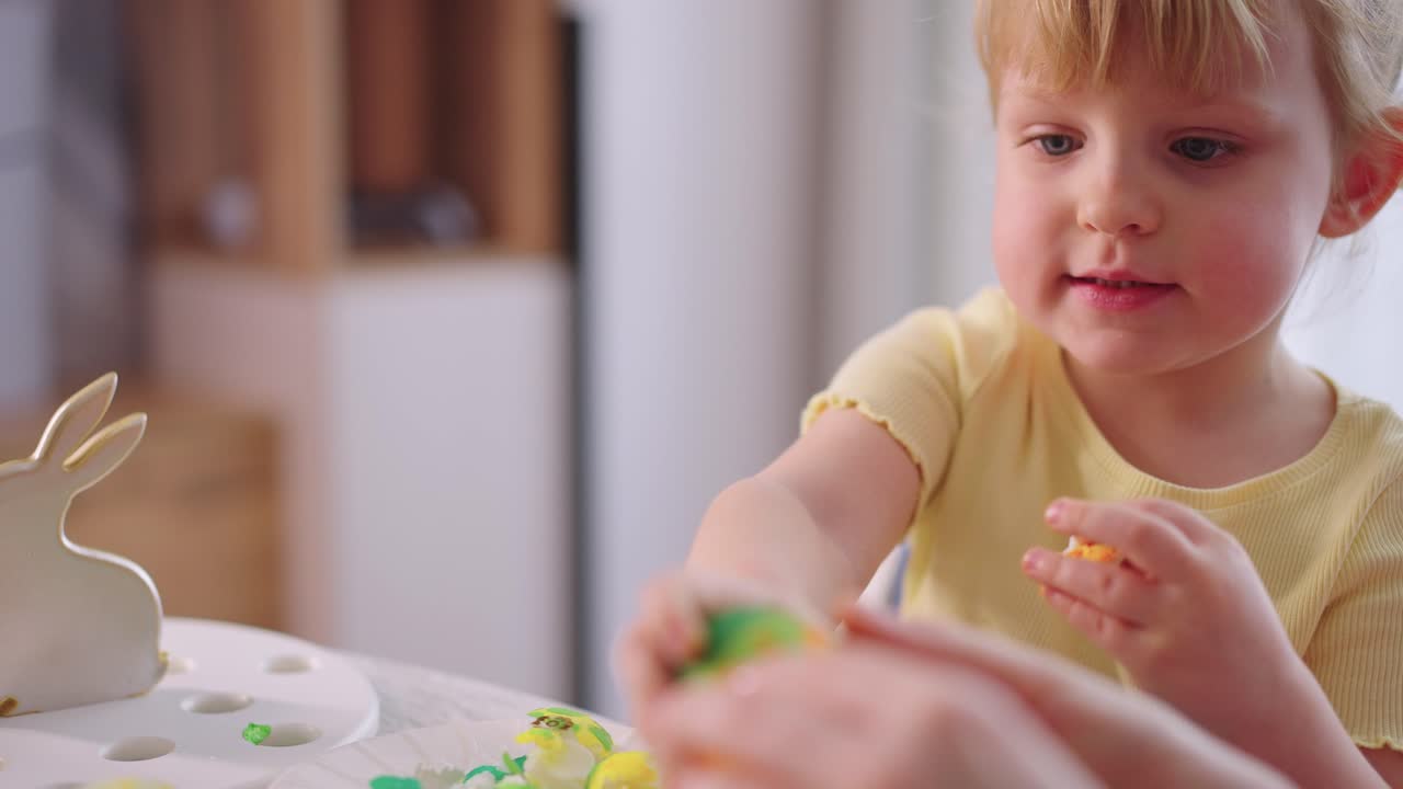 Young Girl Decorating a Colorful Easter Egg