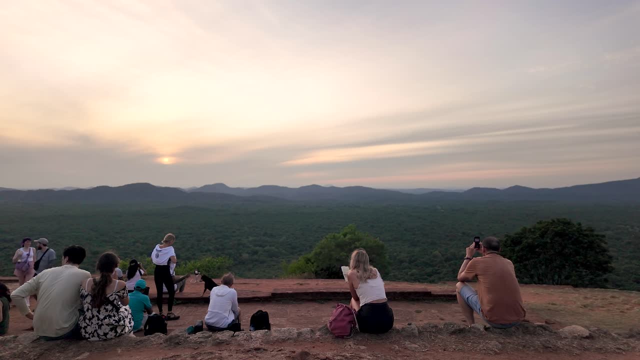 A group of tourists enjoy the breathtaking sunrise view from Sigiriya Lion Rock, capturing the serene landscape of Sri Lanka.