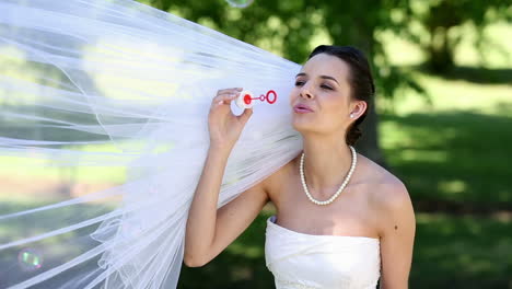 Beautiful-bride-blowing-bubbles-in-the-park