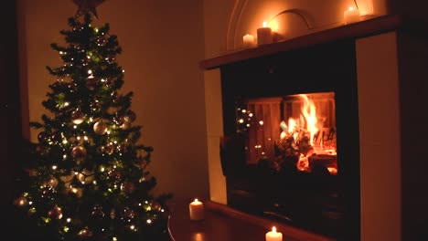 hermoso árbol de navidad con decoración plateada y luces blancas suaves cerca de una chimenea tranquila con velas