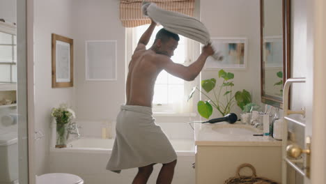 happy-african-american-man-dancing-shirtless-in-bathroom-looking-in-mirror-having-fun-morning-routine-getting-ready-enjoying-positive-self-image-doing-silly-dance-celebrating-success