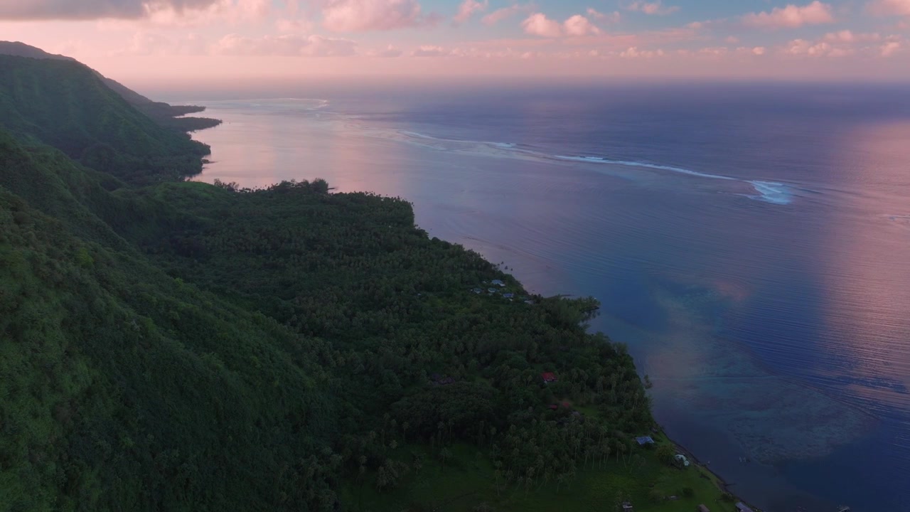 Island coastline of TahitiTeahupo'o South Pacific Ocean French Polynesia aerial drone early morning sunrise clouds Teahupo'o lagoon surfing Passe Havea coral reef break waves mountainside circle right