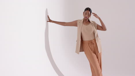 entering studio indian female model approaching circular prop placing hand on edge modeling poses