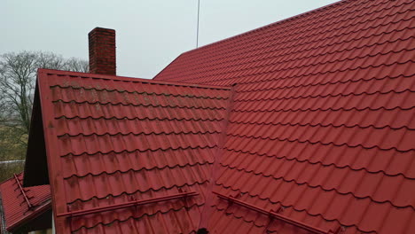 casa con techo de azulejos rojos y chimenea de humo, ubicación rural aérea