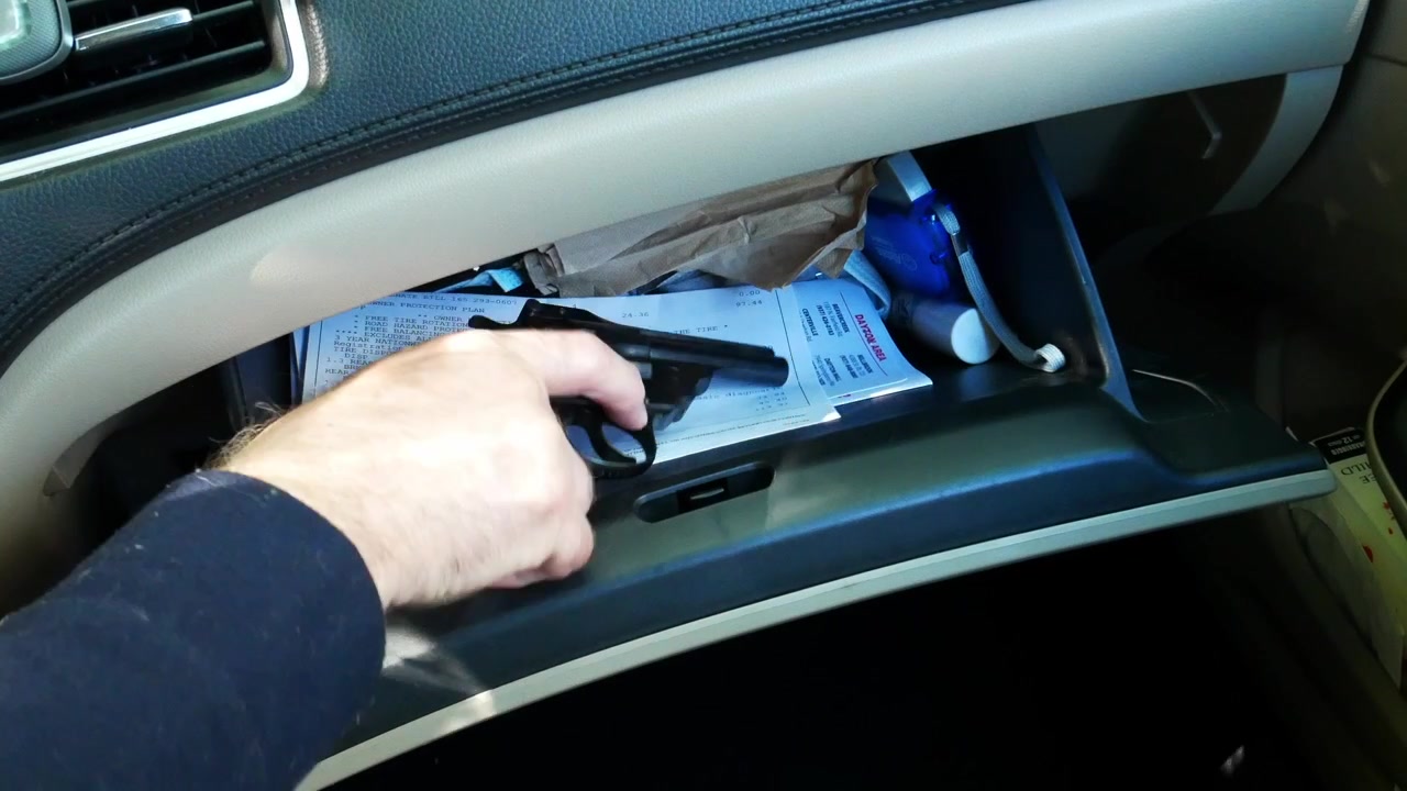 Mann åpner hanskerom i bil for å avsløre pistol