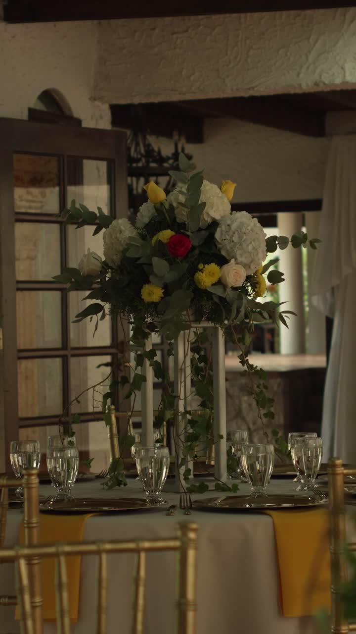 Hall with tables decorated for wedding reception with fresh flowers. Banquet table. Vertical.