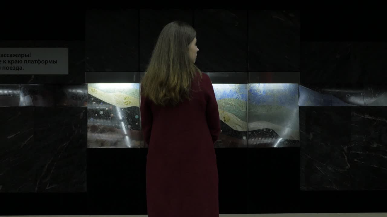 지하철역 에서 미술 설치 를 보고 있는 여자