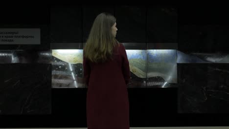 woman in subway station looking at art installation