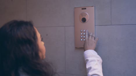 woman using building intercom keypad