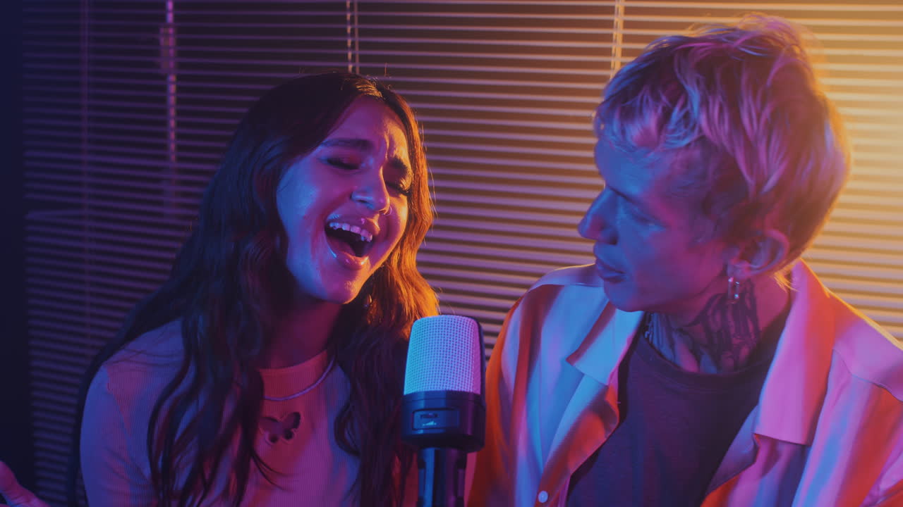 Biracial Duet Performing Song in Microphone at Neon Party