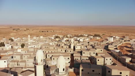 aerial shot of two mosques and some soldiers getting into them in an old empty city in the desert in palestine near gaza at sunset.
