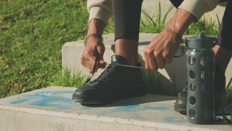 Crop-ethnic-sportsman-tying-shoelaces