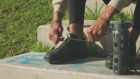 crop deportista étnico atando los cordones de los zapatos