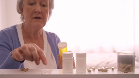 una mujer mayor arreglando unas pastillas.
