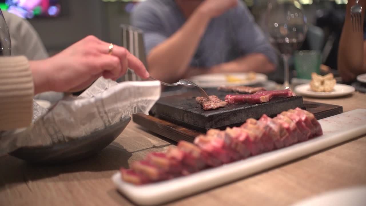 식당에서 생일을 축하하는 식당에서 식사하는 친구들, 토스트, 환호, 핫스톤에서 자신의 고기 준비