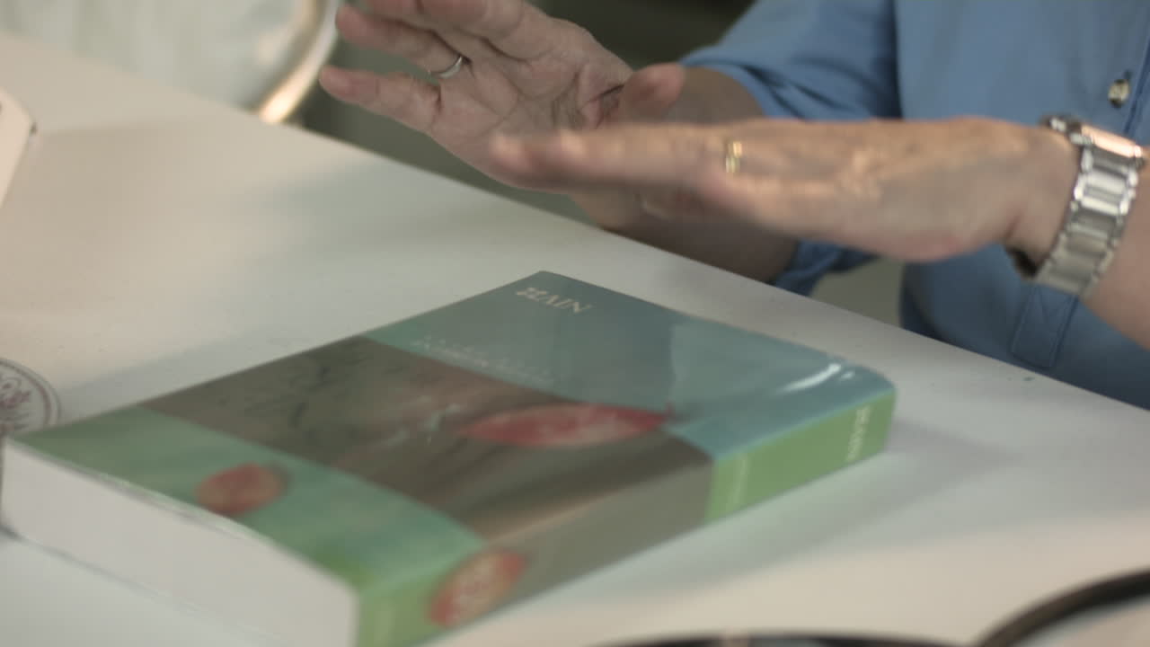 anciana con estetoscopio leyendo un libro y usando su tableta