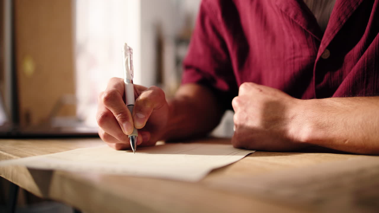 Close-Up of a Person's Hand Writing on Paper with a Pen