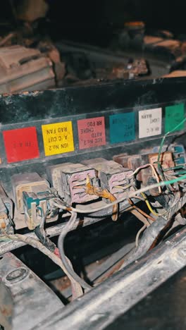 el motor y la caja de fusibles de un suv de patrulla nissan de los años 90 mostrando su mecánica vintage