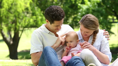 happy parents with their baby girl in the park