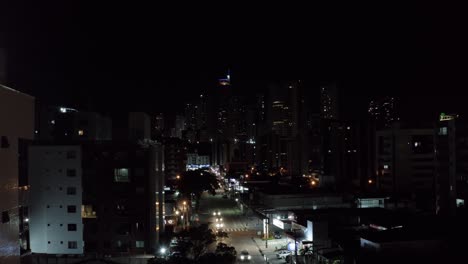 toma nocturna de drones aéreos de la hermosa ciudad capital de la playa tropical de joao pessoa, paraiba, brasil desde el barrio de tambaú con rascacielos, apartamentos y una pequeña calle con tráfico